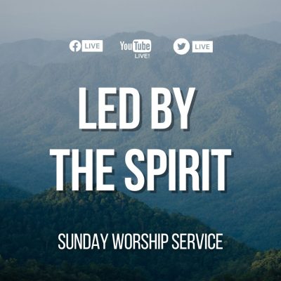 Forested mountains with Led by the Spirit Sign in front